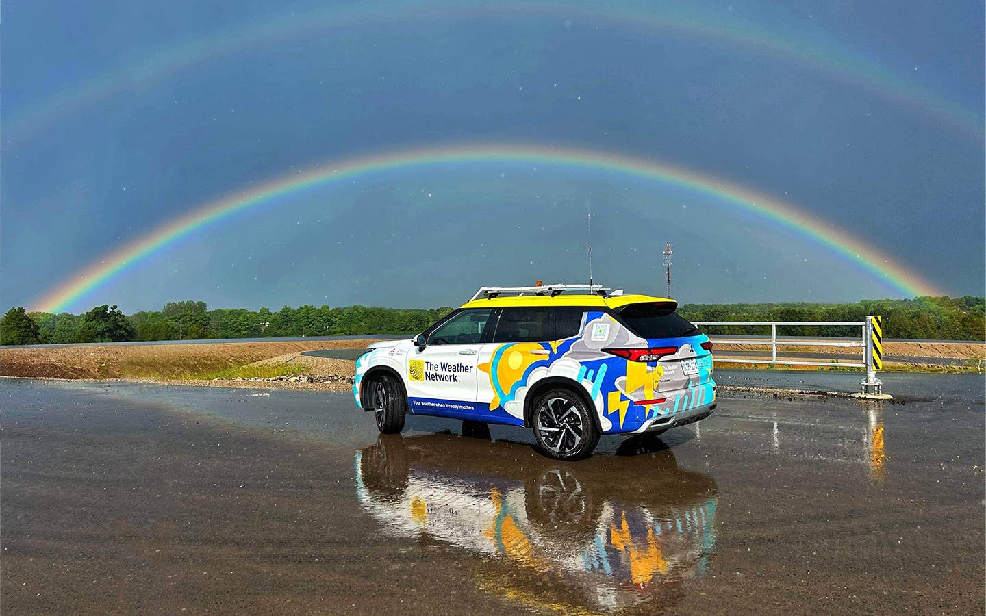 The Weather Network branded Mitsubishi Outlander underneath a double rainbow