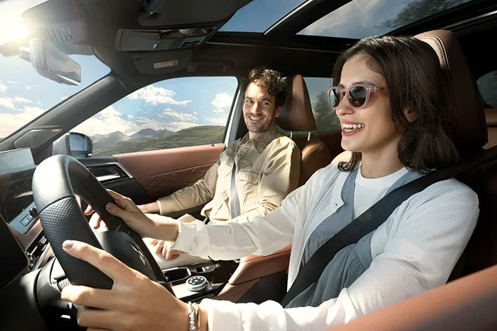 A smiling driver and passenger in the Outlander