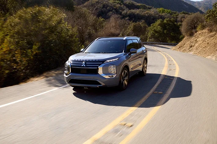 The Outlander driving quickly on an empty road