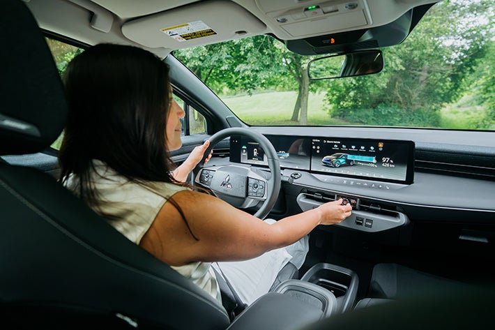 A woman adjusting the volume on the BOSE audio system