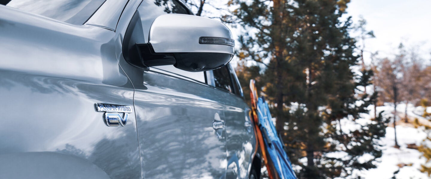 Gros plan du rétroviseur côté conducteur d’un Outlander PHEV 2022 couleur argent de Mitsubishi Motors.